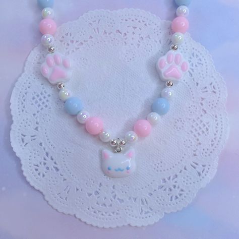 Introducing our delightful "Kawaii Kitty Dreams" Necklace - a whimsical and enchanting accessory that perfectly captures the essence of cuteness and charm. This exquisite necklace is meticulously crafted to bring a touch of magic and joy to your everyday style. Adorned with a delicate arrangement of pastel pink, serene blue, and pristine white beads, the "Kawaii Kitty Dreams" Necklace is a visual symphony of soothing colors. Nestled among these enchanting beads are two dainty stars, reminiscent Dainty Stars, Joyful Expression, Kawaii Kitty, Aesthetic Accessories, Whimsical Accessories, Pastel Beads, Kawaii Jewelry, Cat Pendant, Rose Pastel