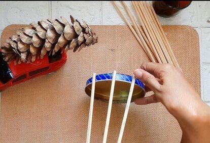 Decorating homes with varieties of Christmas trees is such a joy. And nothing like a DIY tree with materials easily available. In this video I have made a table top Christmas Tree. Here's what I made using very simple and easily available materials. Let's see how I made these gorgeous rustic trees. Step 1The materials you will need areAn old lidSkewer sticksGlue gunJute ropeSome Christmas ornaments Step 2Attach the skewer sticks around the lid. Leave some space between each stick… Rustic Table Top, Cones Diy, Skewer Sticks, Stick Christmas Tree, Cone Trees, How To Make Christmas Tree, Cone Christmas Trees, Diy Tree, Alternative Christmas Tree