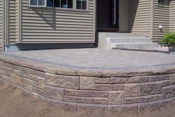 Raised Flagstone Patio, Patio With Retaining Wall Ideas, Paver Patio With Retaining Wall, Retaining Wall Around Patio, Raised Concrete Patio Ideas, Bank Landscaping, Raised Patio Ideas, Raised Paver Patio, Paver Porch