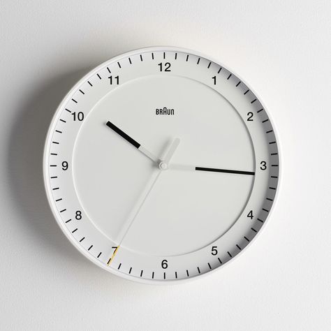 The Braun White Wall Clock was designed in 1982 by Dieter Rams and Dietrich Lubs, two iconic figures in the history of the Braun brand. This clock's simple and sophisticated design eschews any unnecessary features to focus squarely on functionality, accuracy and longevity, resulting in a timepiece that is truly timeless. The large dial with precision quartz movement features contrasting hands and a matte casing that make this white wall clock easy to read. The yellow-tipped second hand sweeps ar Braun Wall Clock, Braun Clock, Designer Clocks, Braun Watches, White Wall Clock, Wall Clock Classic, Minimalist Wall Clocks, White Wall Clocks, Clock Faces