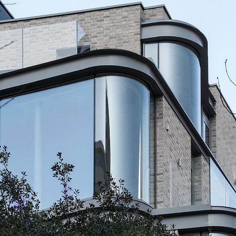 These #curvedwindows were designed in the style of #modernbaywindows which extended out from the building to provide each apartment with a large space to view the surrounding landscape. You can read more about window glazing systems here > Curved Glass Window, Curved Glass Facade, London Apartment Building, Curved Building, Black Building, Australia House, Window Glazing, Facade Architecture Design, Rooftop Design