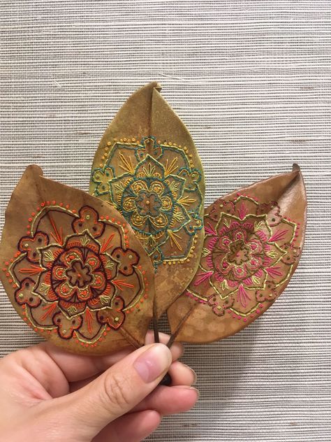 This is an on going collection of hand embroidered magnolia leaves. All of the illustrations for the embroideries are mine, all the leaves are real, and are handled carefully and preserved to last. This is something that I explored back in 2012, and began… Embroided Leaves, Leaf Stiching, Embroidered Magnolia, Autumn Garland, Embroidery Leaf, Leaves Art, Embroidered Leaves, Leaf Crafts, Magnolia Leaves