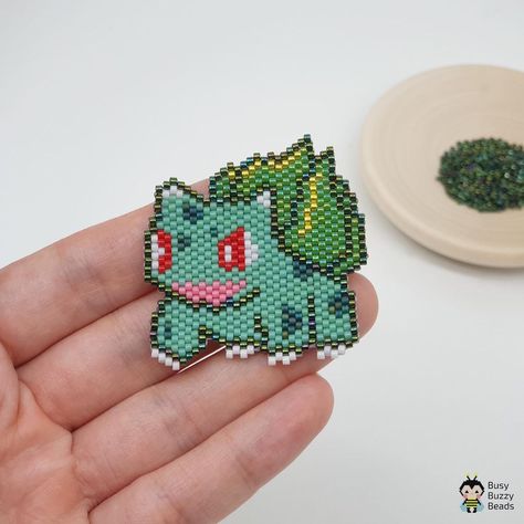 Miyuki Delica beading patterns on Instagram: “Meet another Pokemon - Bulbasaur, my fave too🥰 • ❗️Please do not copy from the picture. • • • #tissageperler #perlesmiyuki…” Beaded Pokemon Pattern, Seed Bead Pokemon, Pokemon Seed Bead Patterns, Brick Stitch Dinosaur, Brick Stitch Pokemon, Pokemon Beads Pattern, Beaded Pokemon, Stitch Bead Pattern, Pokemon Earrings