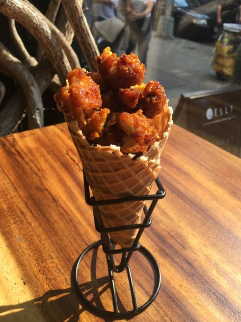 Crispy bits of deep-fried chicken are tossed in a tangy BBQ sauce, then loaded into a sweet waffle cone. Chicken And Waffle Cone Recipe, Chicken And Waffle Cone, Stuffed Waffle Cone Dessert Ideas, Fruit In Cones Waffles, Waffle Cheesecake Cones, Cone Desserts, Stuffed Waffle, S’mores Waffle Cone, Waffle Pops