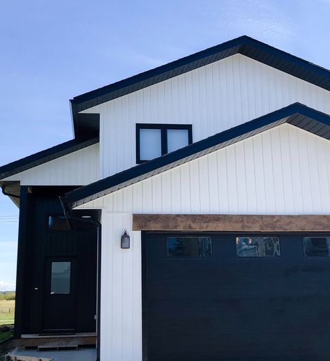 White House Black Garage Door, Black Metal Siding, Farmhouse Siding, White And Black Exterior, Black Garage Door, White Garage Doors, Painted Exterior Doors, House Accents, Black Metal Roof