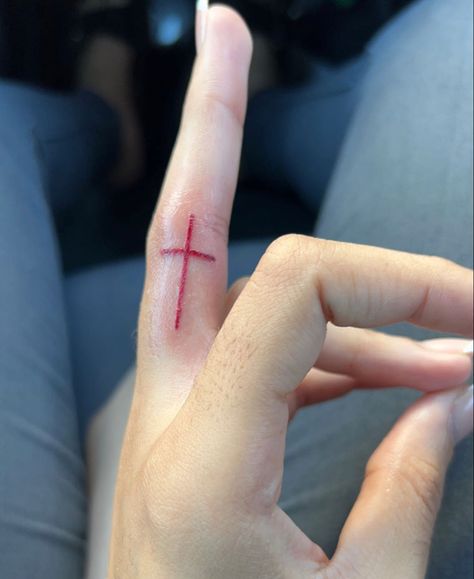 Red Cross Finger Tattoo, Finger Tattoos Red Ink, Red Cross Behind Ear Tattoo, Red Ink Cross Tattoo, Red Tattoo Finger, Cross Tattoo Finger, Tattoo Ideas Female Red Ink, Red Finger Tattoo, Ironic Tattoos