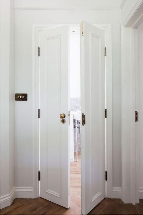 Bi fold bathroom doors adorned with brass door knobs open to a lovely bathroom with wood herringbone floors. Bi Fold Bathroom Door, Bathroom Door Ideas, Bathroom Door Knob, Cheap Closet, Pintu Interior, Bedroom Closet Doors, White Door, Bathroom Closet, 아파트 인테리어