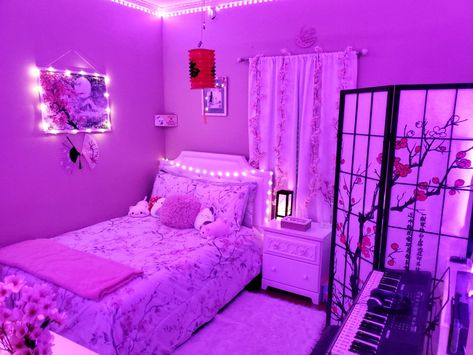 The image features many Japanese decorations. These including a lantern, partition, bedspread, cherry branches/vines, cherry blossom wallart, etc. The overall appeal is the cherry blossoms, which is indicated by the pink, black, white, and gray coloration. Neon Japanese Aesthetic Room, Japanese Theme Bedroom Ideas, Japan Themed Room, Japanese Style Bedroom Aesthetic, Japan Room Ideas, Japanese Teen Bedroom, Japan Room Aesthetic, Anime Themed Bedroom, Japanese Decor Bedroom