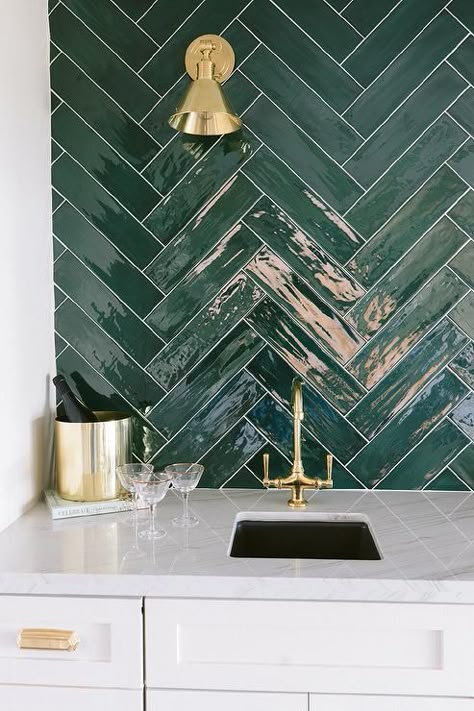 Glossy green herringbone pattern tiles accent a contemporary wet bar with white and gray quartzite countertops and an antique brass vintage faucet. Modern Craftsman Kitchen Ideas, Modern Craftsman Kitchen, Herringbone Wall Tile, Dark Green Tile, Herringbone Tile Backsplash, Green Subway Tile, Patterned Wall Tiles, Green Backsplash, Gray Painted Walls