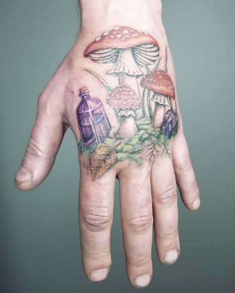 Amanita mushrooms tattoo on the back of a hand. They grow in moss and there is a crystal and a bottle next to them Colour Tattoos, Tattoos Color, Fly Agaric Mushroom, Mushroom Tattoo, Colour Tattoo, Mushroom Color, Mushroom Tattoos, Fly Agaric, The Hand