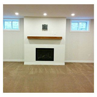 A contemporary drywall surround with a floating oak mantel was created for the gas fireplace, allowing enough room for a TV to be installed above the mantel. Fireplace Drywall, Drywall Fireplace, Oak Mantel, Modern Basement, Fireplace Tv Wall, Creative Interior, Fireplace Surround, Fireplace Remodel, Home Fireplace