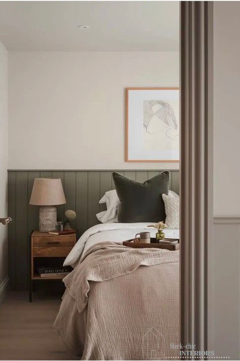 Half wall panelling has long been a popular choice to add instant character and depth to any room of the house.  It provides a perfect opportunity to incorporate another colour into the mix, and we love this green which is complemented by a warm off-white, creating a cosy, soothing look.  If you’re redecorating and looking to create a cosy yet serene and soothing space, let these 23 earthy bedroom ideas inspire you! Panelled Half Walls Bedroom, Shaker Wall Panelling Bedroom, Bedroom With Half Wall Panel, Bedroom Half Wall Paint, Bedroom With Trim On Wall, Bedroom With Board And Batten Wall, Loft Master Bedrooms Decor, Green Paneling Bedroom, Bedroom Half Wall Paneling