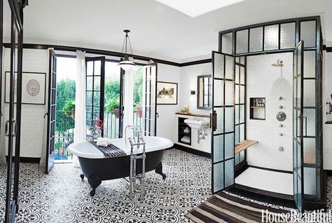 Skylight over steel and frosted glass glass shower with double doors adorned with subway tiled surround, teak shower bench, tiled shower niche and diamond pattern shower floor. Floor to ceiling subway tiled walls are accented with black crown moldings and black base boards frame mirror over wall-mounted sink flanked by built-in cubbies across from black clawfoot bathtub atop black and white quatrefoil tiled floor placed in front of black French doors covered in white curtains. Spanish Bathrooms, Bathroom Industrial Chic, Casita Ideas, Bold Tile, White Bathroom Designs, Victorian Bathroom, Industrial Bathroom, Bad Inspiration, Gorgeous Bathroom