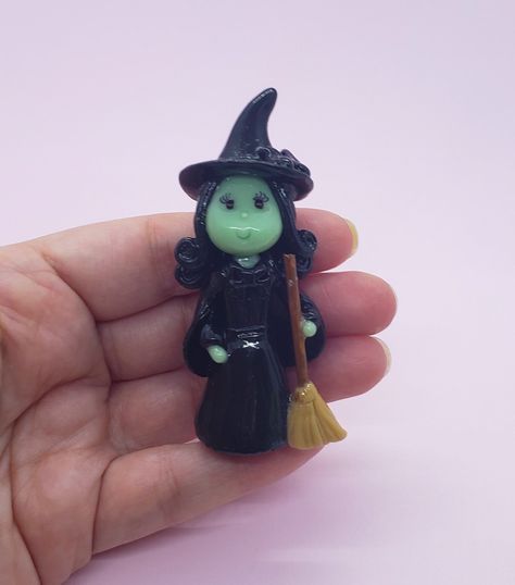 "Ready to ship one of a kind handmade cold porcelain clay Witch Figurine with green skin tone, brown eyes and black hair, holding a broomstick. It is approximately 2.75\" (7 cm) tall. Custom Orders Are Welcome. https://www.etsy.com/shop/coldporcelainbypatty Disclaimer: - This is a handmade piece of art intended to indoors decoration only, it is fragile in nature and should be handled with care, it is not waterproofed, it is not a toy, and it is not intended to be handled by small children, it might contain small pieces which could pose a choking hazard." Brown Eyes And Black Hair, Clay Witch, Cork Ideas, Cold Porcelain Clay, Witch Figurines, Diy Snow Globe, Green Skin, White Glue, Wicked Witch