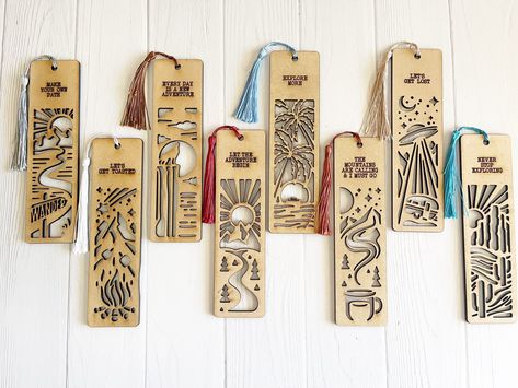 Introducing our delightful Set of 8 Wooden Adventure Bookmarks with Tassels and Inspiring Nature Quotes! Each of these bookmarks features an enchanting outdoor nature scene, ready to whisk you away to endless literary adventures. Crafted with care, these sturdy wooden bookmarks are cut out in intricate designs, creating a visual treat for your reading pleasure.  Measuring 6.75 x 1.75 inches, they fit perfectly inside any book, keeping your place with style. The set includes all eight bookmarks, Glowforge Bookmark, Laser Bookmark, Diy Laser Engraver, Wooden Bookmarks, Book Keeping, Wood Bookmark, Anime Crafts Diy, Inspiring Nature, Diy Laser Cut