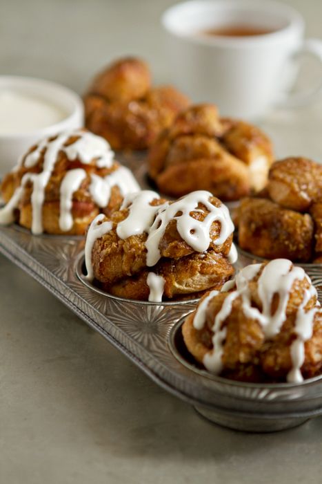 Traditional Monkey Bread gets a mini makeover when it's baked in muffin cups and drizzled with cream cheese icing. They're perfect for breakfast or Easter brunch. Monkey Bread Muffins, Bread Muffins, What's For Breakfast, Monkey Bread, Köstliche Desserts, Muffin Tins, Yummy Sweets, Breakfast Treats, Sweets Treats