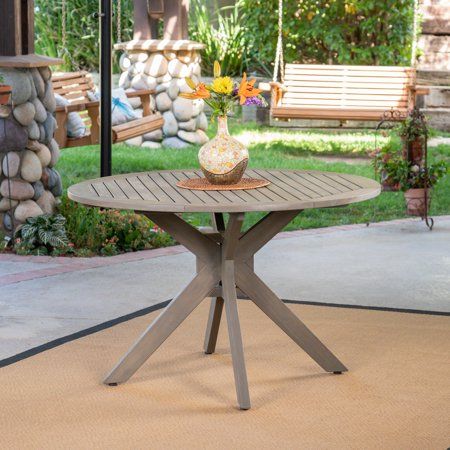 This acacia wood outdoor dining table is a wonderful addition to your patio. With a smooth finish and X-shaped base support, this table is as beautiful as it is functional. Enjoy dinner under the stars with the family or use it as a serving table for when you host summer BBQs, this table does it all. Treated to help withstand the elements, this table was made for your backyard. Color: Gray. Wood Outdoor Dining Table, Acacia Wood Dining Table, Round Wood Table, Acacia Wood Table, Wicker Dining Set, Outdoor Lounge Area, Wicker Dining Chairs, Circular Table, Serving Table