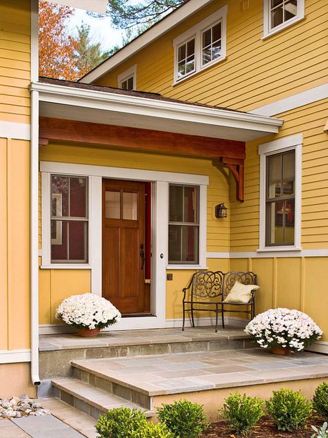 This beautiful wood front door gives guests a warm welcome. More ways to add curb appeal: http://www.bhg.com/home-improvement/exteriors/curb-appeal/ways-to-add-curb-appeal/?socsrc-bhgpin061313tiledoorstep=17 Curb Appeal Porch, Front Porch Design Ideas, Veranda Design, Entryway Light Fixtures, Porch Design Ideas, Front Stoop, Building A Porch, Front Porch Design, Yellow House