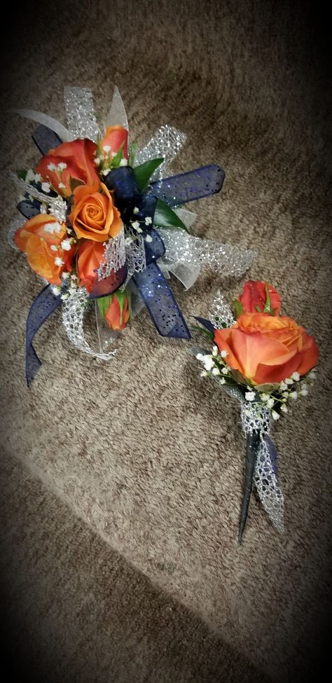 Coral Rose's with navy and silver accents Coral And Navy Wedding Decorations, Orange And Navy Prom, Prom Orange, Homecoming Bouquet, Hoco Flowers, Mickey Wedding, Prom Flowers Corsage, Blue Corsage, Blue Boutonniere