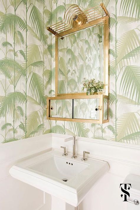 White and green powder room boasts Cole  Son Palm Jungle Wallpaper on upper walls and white tongue and groove trim on lower walls lined with a white pedestal sink and brass mirror with shelf. Green Powder Room, White Powder Room, Summer Thornton, Wallpaper Powder Room, Tropical Bathroom, Wallpaper Book, Modern Townhouse, Palm Leaf Wallpaper, Palm Wallpaper