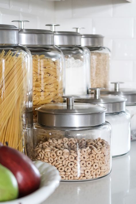 Looking to organize your kitchen and free up cabinet space? Try a counter top glass jar pantry. Store bulk items in airtight containers and clear kitchen counter clutter. #smallkitchenorg #declutterkitchencounters #generalstorepantry #jarpantry #kitchenideas #kitchencounters #smallkitchenideas #porchdaydreamer Glass Jars For Kitchen Storage, Kitchen Glass Jars Display, Glass Canisters In Kitchen Display, Glass Jars Kitchen Counter, Men Cupcakes, Jar Pantry, Storage Jars Kitchen, Organize Kitchen Countertops, Kitchen Dining Room Combo