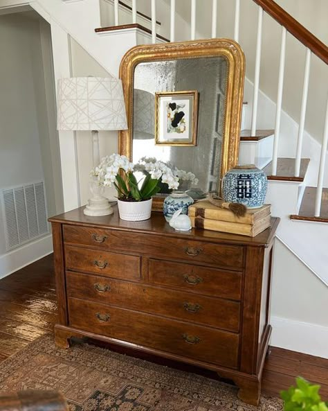 Joan on Instagram: "The spring entry chest! Antique English chest of drawers topped with an antique Louis Phillippe mirror, a vintage alabaster lamp with a fun geometric (tone on tone shade), circa 17th c. Vellum covered books, antique Chinese double happiness and Canton- blue and white ginger jars, an antique Chinese horn-handled natural bristles brush, and a white planter filled with real white orchids (sans hair clips😉) ,and a white porcelain rabbit that was in my Easter basket when I was a Entry Chest Of Drawers, Chest Of Drawers Entryway, Dresser In Hallway Decor, Lamp On Top Of Books, Small Corner Living Room, Painting On The Mirror, Condo Entryway, Chest Of Drawers With Mirror, 1930s Furniture