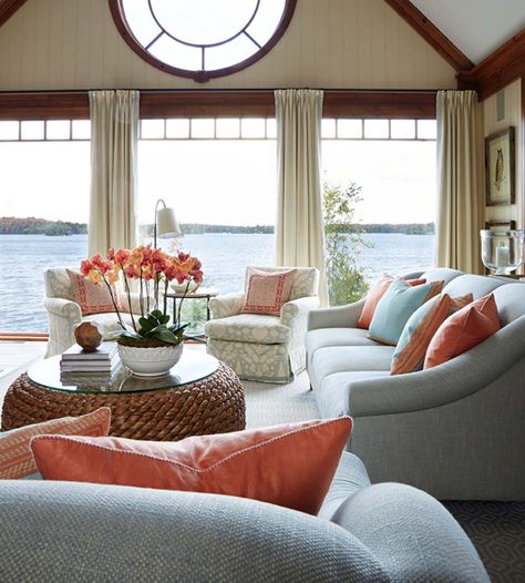 A delightful Muskoka lake house with a soothing ambiance Salmon And Blue Living Room, Coral Coastal Living Room, Coral Decorating Ideas Living Room, Coral And Blue Living Room, Teal Beach House, Coral Beach House, Lake House Living Room Decor, Cozy Coastal Living Room, Coastal Style Living Room