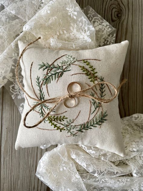 8” x 8” ring bearer pillow made from cream colored muslin. The pillow has a wreath with embroidered herbs and botanicals embroidered on the front. It is stuffed with poly fiberfill and has a jute chord attached. Embroidered Herbs, Electrified Wood, Botanical Ring, Botanical Plants, Hand Embroidered Pillows, Wedding Pillows, Ring Bearer Pillow, Ring Pillow, Floral Ring