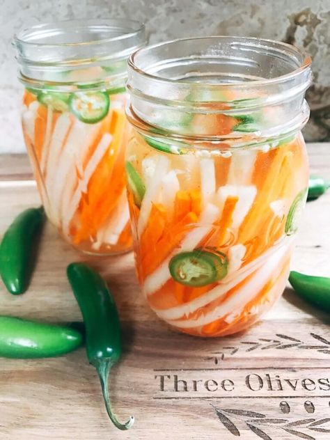 Simple and easy pickled vegetables perfect for your banh mi! Use as a quick condiment on your favorite foods. Daikon radish and carrots are made spicy with serrano. A rice vinegar base is ready in just minutes for this classic Vietnamese slaw. Use cucumber or your favorite vegetables. Vegan and vegetarian. Spicy Vietnamese Pickled Vegetables | Three Olives Branch | www.threeolivesbranch.com Vietnamese Slaw, Vietnamese Pickles, Vietnamese Pickled Vegetables, Vegan Banh Mi, Diy Condiments, Vietnamese Recipe, Pickled Vegetables Recipe, Warm Potato Salads, Daikon Radish