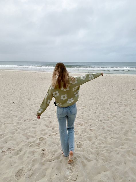 Green sweater with white flowers. Straight leg denim jeans. Chilly day at the beach outfit.