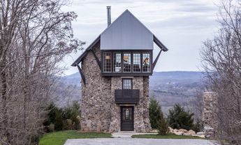 You probably won't have to worry about archers and invaders on horseback, but that doesn't mean this lookout-inspired home in the Smoky Mountains is pointless. Designed by Pfeffer Torode Architecture, the unique home shoots up instead of out, allowing occupants to enjoy 360° views after scaling the stunning spiral staircase. House Exterior Brick, Brick Garage, Tower House, Casa Container, Spiral Staircase, Stone Houses, Stone House, Exterior Brick, Style At Home