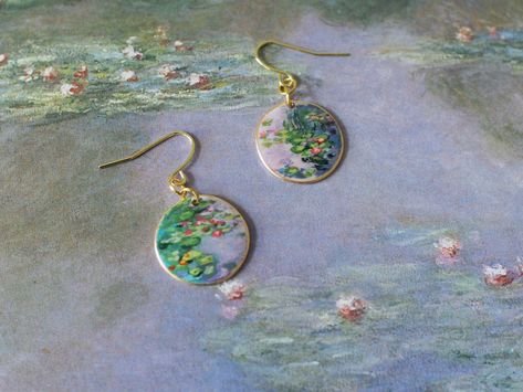 Hand-painted earrings inspired by Monet's Water Lilies. NOT made from photos or prints, they are 100% hand-painted on resin and varnished with a gloss coat, making the beautiful colors lasting long.    * Pendant diameter: 3/4 inches These painted earrings capture a moment of the ever-changing reflective body of water. You can see the play of light on the pond where colors of green, blue, purple, pink, yellow, and orange contrast and complement each other.   A thoughtful gift for birthdays, anniv Kinder Graduation Gifts, Art Claude Monet, Painting Earrings, October Jewelry, Blue And White Earrings, Monet Earrings, Monet Water Lilies, Beads Craft Jewelry, Hand Painted Earrings