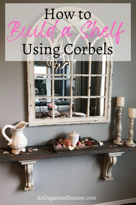 A decorated shelf made with corbels sitting below a mirror. Floating Shelf With Corbels, Floating Shelves With Corbels, Diy Shelf With Corbels, Mirror With Shelf Underneath, Decorating With Corbels Ideas, Shelves With Corbels, Shelf With Corbels, Build A Shelf, Antique Corbels