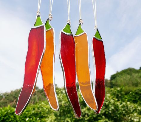 Hand made stained glass orange chilli pepper sun-catcher made using the copper foil technique. Lovely bright orange glass with a green stalk. Great for the kitchen! Please note that this listing is for ONE ORANGE chilli. Also available in red and green in Fruit and Veg section of my shop https://etsy.me/3i2BkoP Ideal gift or decoration. Chilli pepper gift, chilli lover gift. Fathers day gift. Hang at the window to let the light shine through. Measures approx 13 x 2.5 cm. All orders to the US are Stained Glass Vegetables, Exquisite Decor, Making Stained Glass, Stained Glass Decor, Food Stains, Glass Bottle Crafts, Chilli Pepper, Stained Glass Crafts, Glass Fusing