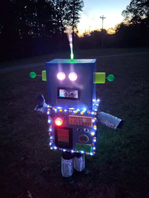 Use of cardboard boxes, battery operated lights, spray paint, hot glue, painter's tape and other craft supplies Futuristic Robot Costume, Halloween Robot Costume, Robot Halloween Costume Diy, Toddler Robot Costume Diy, Adult Robot Costume, Robot Costume Toddler, Wild Robot Costume, Homemade Robot Costume, Toddler Robot Costume