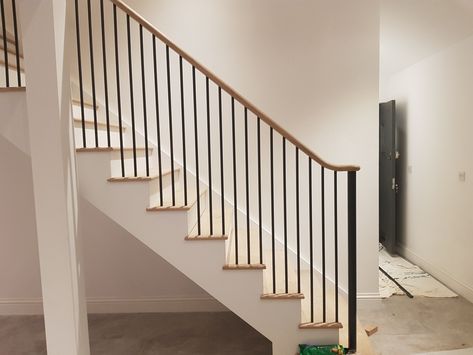 Fitting in progress for this staircase featuring round metal spindles and a continuous handrail. Oak Staircase With Metal Spindles, Black Wood Spindles Staircase, Staircase Metal Spindles, Black Metal Spindles Staircase, Stairs With Metal Spindles, Staircase Spindle Ideas, Metal Spindles Staircase, Iron Spindle Staircase, Remodel Staircase