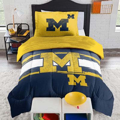 Show your team spirit with our Officially Licensed NCAA Michigan Wolverines Comforter & Sham Set from Northwest. Made with ultra soft Polyester microfiber outer fabric and Polyester Down Alternative fill for the greatest comfort while you dream of your team's victory. The Comforter set print features team name, logo and helmet design. Size: Twin Extra Long Comforter + 1 Standard Shams | Sweet Home Collection NCAA Michigan Wolverines Officially Licensed Comforter & Sham Set Polyester / Polyfill / Football Bedroom, Kids Sheet Sets, Sports Bedding, Round Chair Cushions, Kids Sheets, Rocking Chair Cushions, Patio Chair Cushions, Satin Sheets, Bedding Essentials