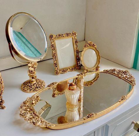 These luxurious vanity pieces feature gilt roses in an intricate perforated pattern.  Made in the 1960s by Matson, USA. (If interested in this line, I also have the matching Ormolu Casket Lidded Jewelry box listed separately). Choose from: 1. Oval Perfume Vanity Mirror Tray 17" x 8.25" - Velvet backed, Excellent vintage Condition 2. Table top Pedestal Swivel Mirror, one side magnified, the other standard mirror. Stable and swivels smoothly. 10" tall, mirror is 6" diameter circle. Excellent vintage Condition 3. Table top Rectangular Picture Frame 6.25" x 4.75" - velvet backed, Excellent vintage Condition 4. Table top oval frame 5" x 3.25" - velvet backed, Excellent vintage Condition PLEASE READ OUR "ABOUT" SECTION FOR SHOP POLICIES ETC. Freshman Wallpaper, Vintage Antique Aesthetic, Vintage Vanity Aesthetic, Luxurious Vanity, Perfume Trays, Vintage Vanity Decor, Perfume Vanity, Table Top Accessories, Swivel Mirror