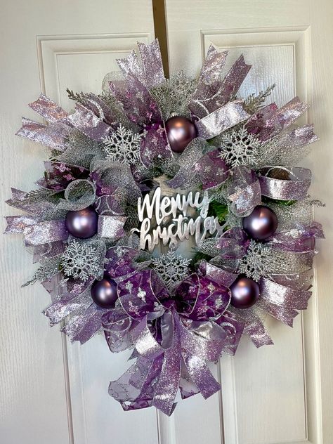 Stunning silver mesh covers this wreath along with three beautiful purple ribbons with glitter accents it also includes 5 purple ornaments and twinkle silver snowflakes. To top it off a silver merry Christmas sign in the middle Purple Mesh Wreaths For Front Door, Purple Wreaths For Front Door, Purple And Silver Christmas, Purple Christmas Tree Decorations, Purple Christmas Wreath, Plum Christmas, Silver Christmas Wreath, Holiday Centerpieces Christmas, Centerpieces Christmas