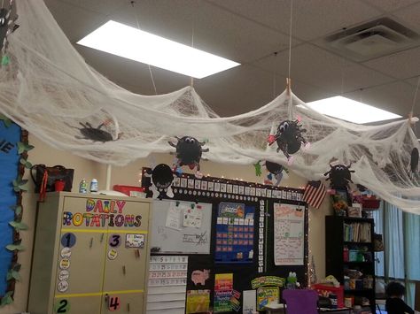 Spider web hanging from ceiling with kid-made spiders attached!! Halloween Decorations Hanging From Ceiling, Spider Web Classroom Decoration, Spider Classroom Transformation, Spider Room Transformation, Halloween Room Transformation Classroom, Spider Classroom Decoration, Halloween Classroom Transformation Ideas, Halloween Classroom Decorations Ceiling, Halloween Decorations Ceiling