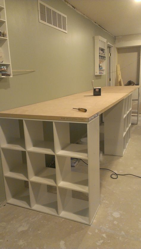 DIY work table... Three 9 cube shelves from lowes Two hollow doors from lowes. This work table is 13' long Diy Craft Room Desk, Cube Shelving Unit, Craft Room Desk, Craft Tables With Storage, Craft Room Tables, Craft Table Diy, Desk Diy, Dream Craft Room, Craft Room Design