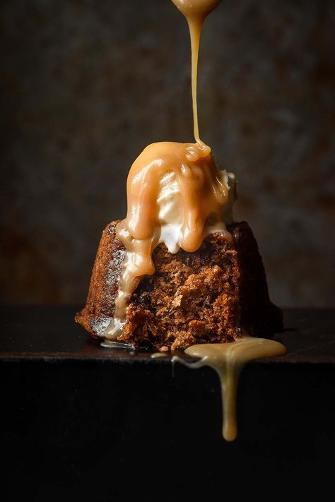 A moody side on image of a gluten free sticky date pudding on a black tin against a dark backdrop. The pudding is topped with melting vanilla ice cream and a stream of butterscotch sauce pours onto the pudding from the top of the image. Butterscotch Sauce Recipes, Homemade German Chocolate Cake, Sticky Date, Sticky Date Pudding, Date Pudding, British Desserts, Toffee Pudding, Sticky Toffee Pudding, Chocolate Lava