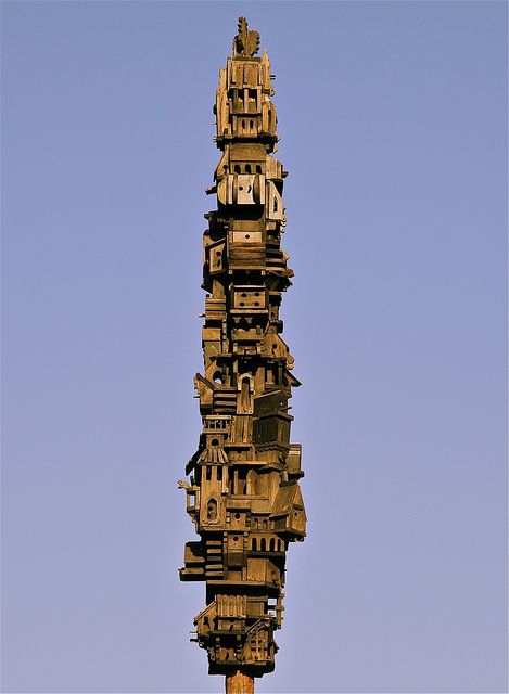 Birdhouse in Washington Park • Albany, NY, Becca James: "Rising some thirty feet in the air, the carved wooden structure features whimsical miniatures facades which range from simple Greek temple columns to gingerbread-like Swiss chalets. The birdhouse was built in 1974, removed in 2001 due to detorioration, and restored in 2005. It was the work of William Schade. Schade, who taught art at Sage College, passed away in 2008."| Flickr - Photo Sharing! Beautiful Birdhouses, Garden Birdhouses, Butterfly Houses, Greek Temple, Cardboard Sculpture, Washington Park, Gnome House, Albany Ny, Stuff And Thangs