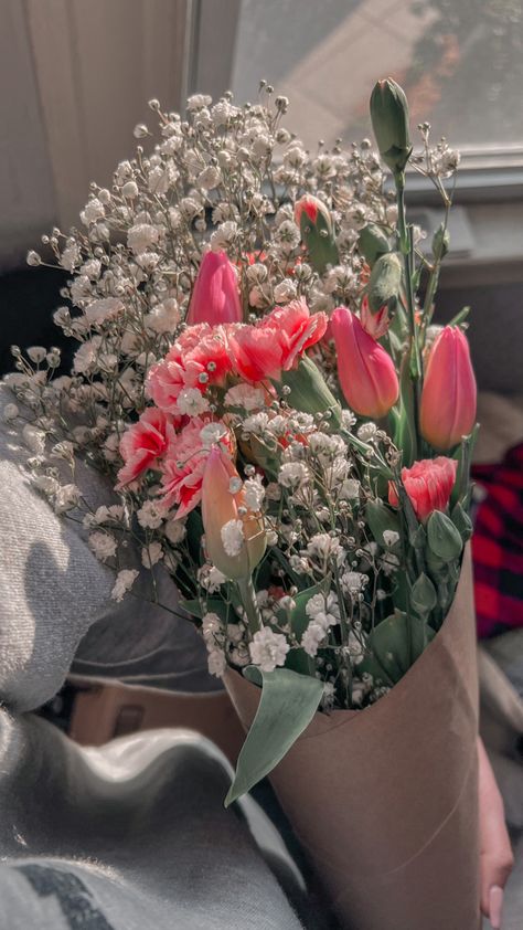 The sun shining on a bouquet of flowers. The bouquet includes pink tulips, pink carnations, and white baby’s breath. The flowers are wrapped in brown paper. Mother’s Day Aesthetics, Tulips And Carnations Bouquet, Tulip Carnation Bouquet, Tulips And Baby Breath Bouquet, Tulip And Carnation Bouquet, Mother's Day Aesthetic, Carnation Bouquet Aesthetic, Mothers Day Aesthetic, Pink Tulips And Baby Breath