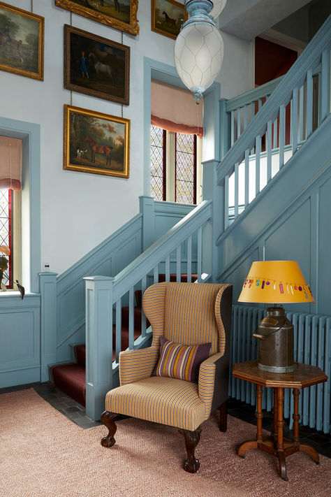 Blue wooden statement staircase with accent chair and mustard lamp shade. Hues of pale blue, gold and brown. Hallway Furniture Ideas, Blue Staircase, Hallway Panelling, Nicola Harding, Blue Hallway, Hallway Paint, Painted Staircases, House Staircase, Hallway Design