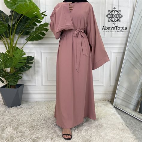 Need a plain and simple closed, loose pink coloured abaya, with a slight flare? Look no further - feel super comfortable in this flowy abaya, especially with it's extra wide sleeves! Perfect to stay cool in the warmer months. Comes with a matching belt too for a more tailored look if you wish. Material: Soft Nidha Sizes are based on length (52"-60") and there may be 1-3 cm differences in the actual item. We also sell similar items in these different colours: Black, Brick Orange, Brown, Dark Khak Abaya With Belt, Modern Kaftan, Elegant Kimono, Abaya Design, Abaya Kimono, Baby Pink Color, Embroidered Midi Dress, Abaya Designs, Abaya Dress