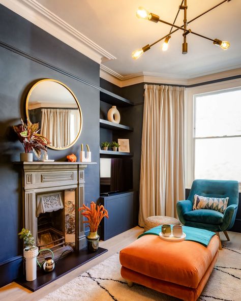 Who says dark walls can’t feel light? 🌌 This deep blue room gets a lift from natural light, bright accents, and a stunning brass lighting fixture. The balance between moody and vibrant makes this space feel dynamic yet cosy. 🎨 @farrowandball “Hague Blue” 📸 @lsouza_photography #DarkInteriors #BlueRoom #MoodyDesign #NaturalLight #FireplaceStyle #BoldAccents #InteriorStyling #CosyCorners #BrassLighting #HomeInspo #TealAndOrange Deep Blue Room, Blue And Orange Living Room, Navy Living Room, Navy Accent Walls, Navy Living, Fireplace Style, Navy Living Rooms, Snug Room, Hague Blue