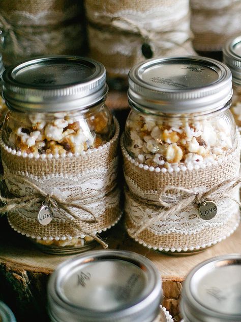 Wrap mason jars with lace and burlap decorations for rustic wedding favors that present caramel popcorn favors in a fashion-forward way. Irish Wedding Favors, Rustic Party Favors, Mason Jar Wedding Favors, Bridal Shower Favors Diy, Rustic Bridal Shower Favors, Wedding Favour Jars, Popcorn Favors, Creative Wedding Favors, Inexpensive Wedding Favors