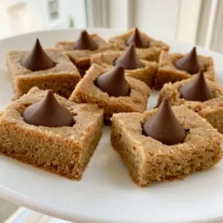 peanut butter blossom bars on a white plate Blossom Bars, Peanut Butter Kiss, Peanut Butter Blossom, Peanut Butter Bars Recipe, Peanut Butter Kiss Cookies, Fall Feast, Butter Blossoms, Peanut Butter Blossom Cookies, Christmas Cookie Recipe