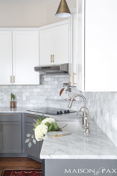 Two-toned gray and white cabinets, marble subway tile, Carrara countertops, a big farmhouse sink, and brass hardware give this kitchen a classic yet modern look. Gray And White Cabinets, Big Farmhouse, Marble Subway Tile, White Marble Kitchen, Серая Кухня, Gray And White Kitchen, Marble Kitchen, Kabinet Dapur, Farmhouse Kitchen Cabinets